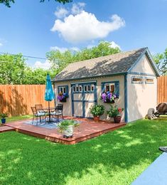 a backyard with a shed, deck and patio furniture in the back yard on a sunny day