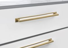 two white drawers with brass handles and marble counter tops, one is open to the other side