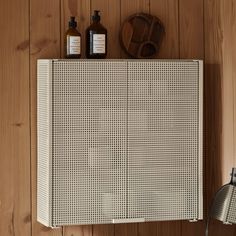 a wooden wall with some bottles on top of it and a basket next to it