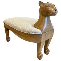 a wooden bench with a stuffed animal on it's back and seat cushion in the shape of a lion