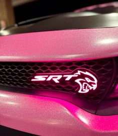 a pink sports car with the word srt on it's front grills