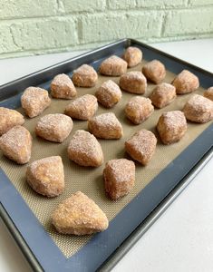 some sugared donuts are sitting on a baking sheet and ready to go into the oven