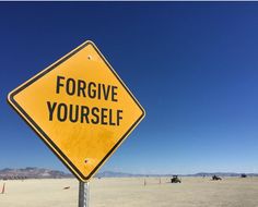 a yellow sign that says forgve yourself on it in the middle of nowhere