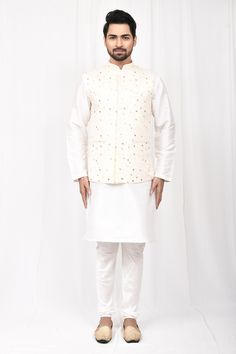 Beige embroidered bundi with mandarin collar. Paired with full sleeve kurta and churidar.
Component: 3
Pattern: Embroidered
Neckline: Mandarin Collar
Sleeve Type: Bundi: Sleeveless, Kurta: Full Sleeves
Fabric: Art Silk
Color: Beige,White
Other Details: 
Front patch pocket
Side slitted kurta
Occasion: Puja - Aza Fashions Sleeveless Kurta, Kurta Set For Men, White Kurta, Beige Art, Nehru Jackets, Embroidered Neckline, Fashion App, Churidar, Kurta Set