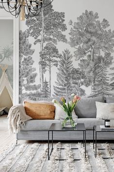 a living room with a couch, coffee table and potted plants