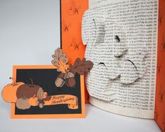 an open book with the pages cut out and decorated to look like a happy thanksgiving turkey