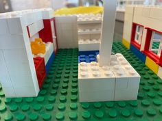 several legos are arranged on a table in front of each other and one has a building made out of lego blocks