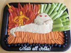 a tray with carrots, celery, and other vegetables in the shape of a cat