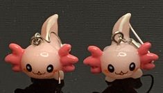 pair of pink and black earrings with white ears on top of each earring, sitting next to each other