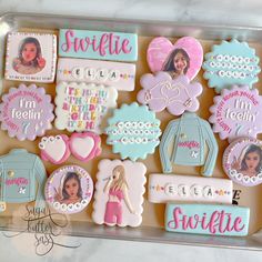 decorated cookies in the shape of barbie's outfits and name tags on a cookie sheet