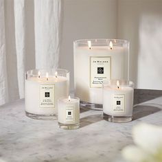 three candles sitting on top of a marble table