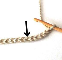 the end of a crochet hook is shown with an arrow pointing towards it