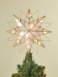 a star shaped christmas tree topper with lights on it's sides and a pine cone underneath