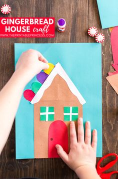 a child is making a gingerbread house out of paper and construction paper with scissors