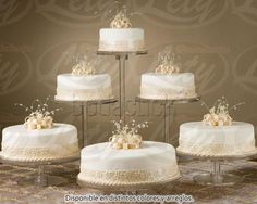 four tiered wedding cake with white frosting and bows on each layer, decorated with pearls