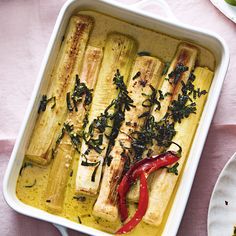 an entree is served in a casserole dish on a pink tablecloth