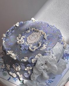 a blue and white decorated cake sitting on top of a table