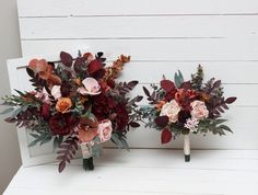 two bridal bouquets sitting on top of a white bench next to each other