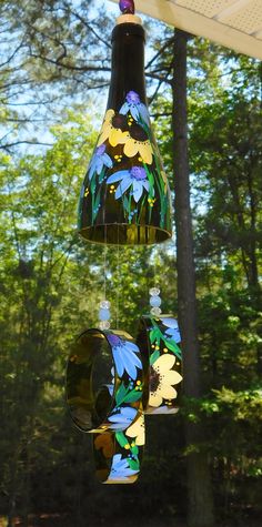 a wind chime hanging from the side of a wooden structure with flowers painted on it