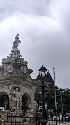 an ornate fountain in front of a building with a statue on it's side