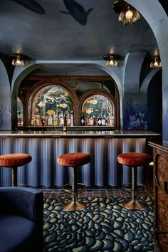 a bar with three stools in front of it