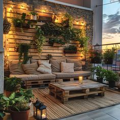 an outdoor living area with wooden pallets and potted plants