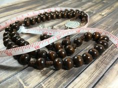 This brown wooden cord rosary is simple yet perfect! It fits nicely in the pocket and is lightweight, great for anytime. This particular cord rosary is made with 10mm dark wood beads and nylon cord. The beads are strung on and then I make a fancy not on either side of the glory be bead. It is adorned with the Holy shroud centerpiece and the Holy Trinity crucifix. Materials used: ~10mm Wood beads ~Nylon cord ~Shroud centerpiece ~Trinity crucifix *Made in my pet and smoke free home. CautionNot for Adjustable Brown Wooden Beads Rosary, Adjustable Brown Wooden Bead Rosary, Adjustable Brown Wooden Rosary, Brown Rosary With 8mm Beads And Cross Shape, Brown Rosary With 8mm Beads, Glory Be, Pocket Rosary, Rosary Gift, The Holy Trinity