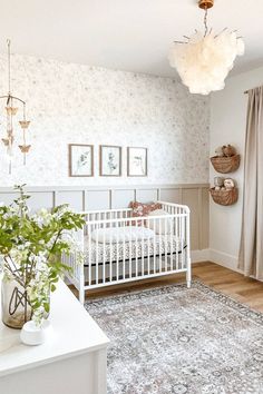 a baby's room with a crib, rug and pictures on the wall