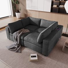 a grey couch sitting on top of a rug in a living room