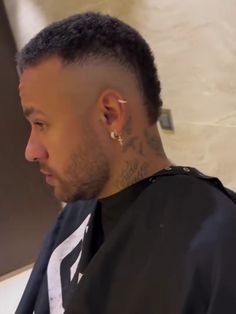 a close up of a person with tattoos on his head and ear piercings, looking off to the side