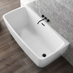 a white bath tub sitting on top of a wooden floor