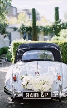 an old fashioned car with flowers on the back