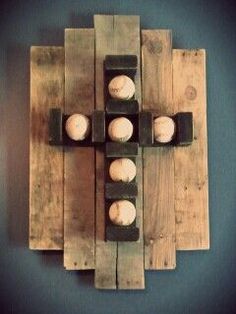 a cross made out of wooden planks with baseballs in it on the wall