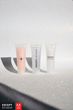 three different types of skin care products on a white surface with sparkles in the background