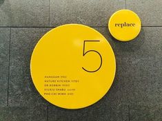 a yellow sign with the number five on it next to another sign that says replace