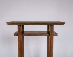 a wooden table sitting on top of a hard wood floor next to a white wall