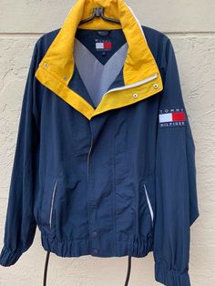 Vintage 90’s Tommy Hilfiger hoodie windbreaker jacket ! In blue and yellow colors, with spell out on collar and big flag logo ! In excellent condition ! Marked size L, but please refer to measurements ! Measurements Pit to pit: 28" Sleeves: 33” (from the collar seam down)  Length: 30” (base of collar to bottom of back) ~~~~~~~~~~~~~~~~~~~~~~~~~~~~~~~~ Please Note: In the unlikely event that you encounter an issue with your purchase, please contact me so that I can help you resolve the problem 90s Tommy Hilfiger, Tommy Hilfiger Hooded Streetwear Outerwear, Hooded Tommy Hilfiger Outerwear For Streetwear, Tommy Hilfiger Hooded Outerwear For Streetwear, Tommy Hilfiger Sporty Streetwear Windbreaker, Casual Hooded Tommy Hilfiger Windbreaker, Tommy Hilfiger Casual Hooded Windbreaker, Tommy Hilfiger Sporty Windbreaker For Streetwear, Tommy Hilfiger Casual Outdoor Windbreaker