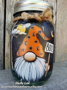 a painted jar sitting on top of a wooden table