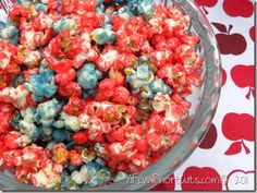 a bowl filled with red, white and blue popcorn on top of a tablecloth