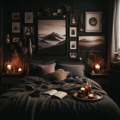 a dark bedroom with candles and pictures on the wall