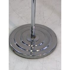 a metal table with a white marble top and silver base on the bottom is an umbrella stand