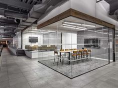 an empty office with glass walls and chairs