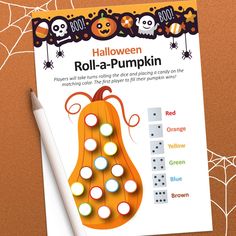 the halloween roll - a - pumpkin game is shown on top of a table with a pen