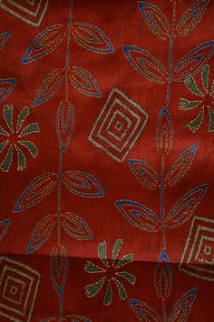 an image of a red cloth with blue and green designs on it's surface