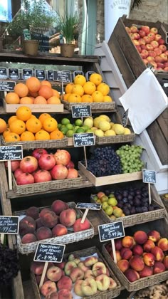 an assortment of fruits are on display at the farmers'market, including plums, peaches, and other fruit