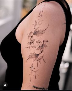 a woman with a tattoo on her arm has a koi fish and bamboo leaves