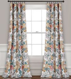 the curtains in this room are decorated with flowers and leaves, while the window is closed