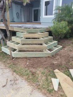 some wooden steps sitting in front of a house with palm trees and grass around them