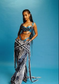 a woman in a blue and black belly dance outfit with her hands on her hips