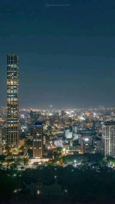 the city skyline is lit up at night with lights in the buildings and skyscrapers